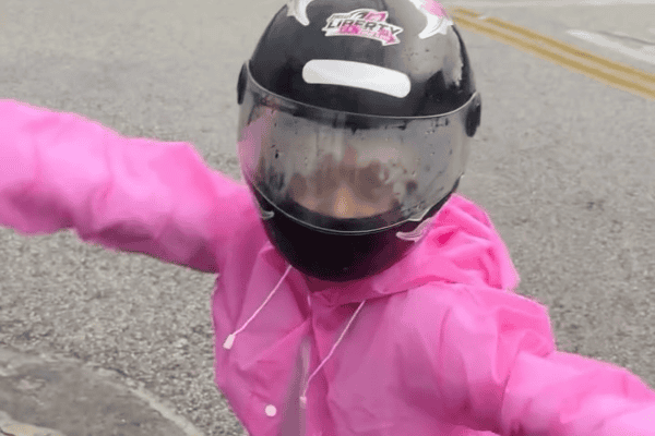 Pai coloca filha no baú da moto para protegê-la da chuva e cena viraliza